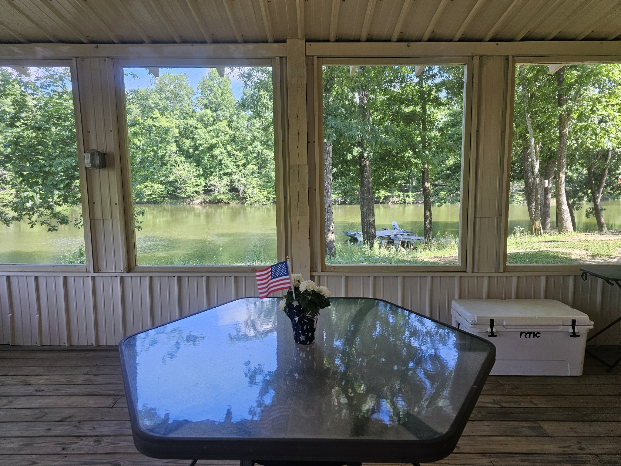 a view of a living room and floor to ceiling window with wooden floor