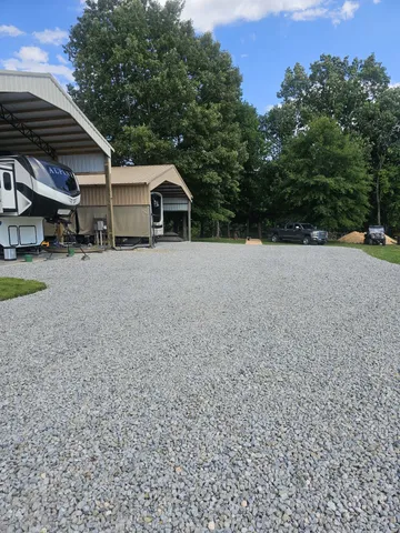 a view of a house with a yard and large trees