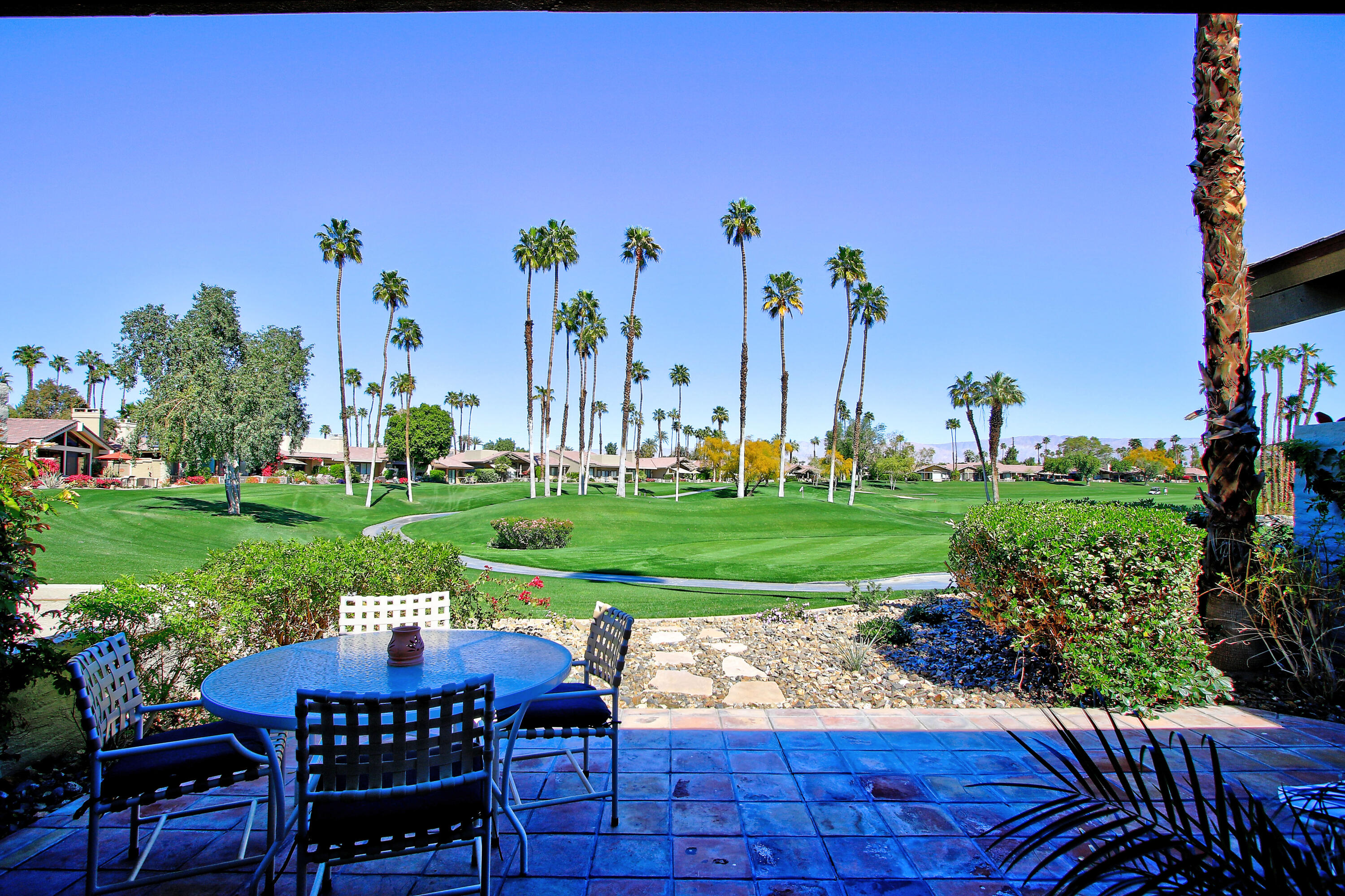 a view of a chairs and table in backyard of the house