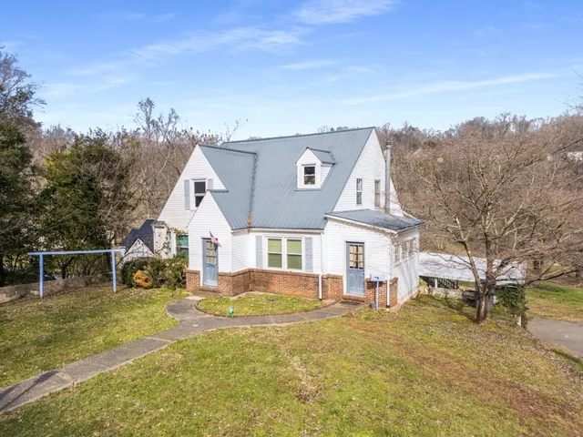an aerial view of a house with swimming pool and sitting area