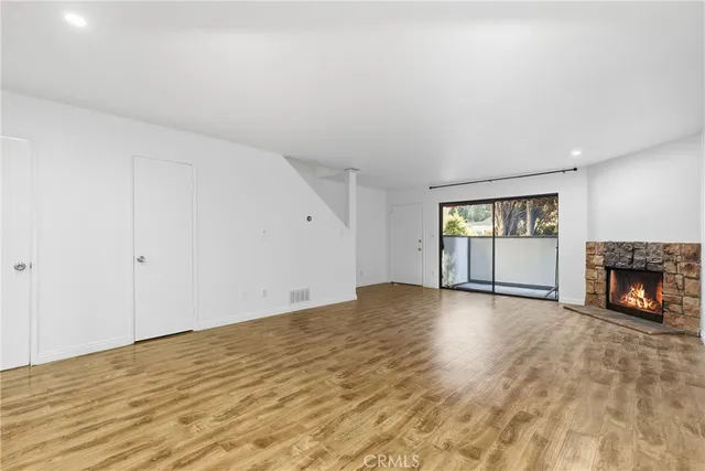 a view of an empty room with window and fire place