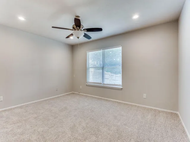 en empty room with windows and ceiling fan view