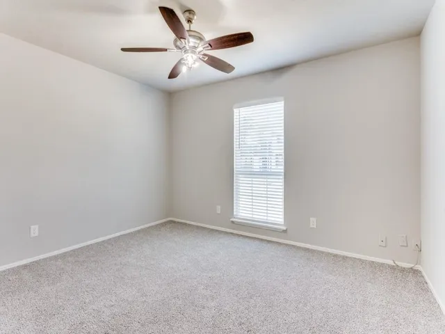 an empty room with a empty space and a ceiling fan
