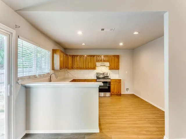 a kitchen with stainless steel appliances granite countertop a sink and a stove