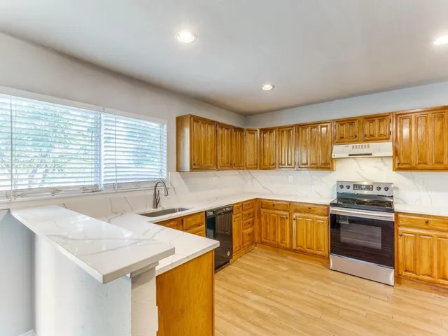 a kitchen with stainless steel appliances granite countertop a sink and cabinets