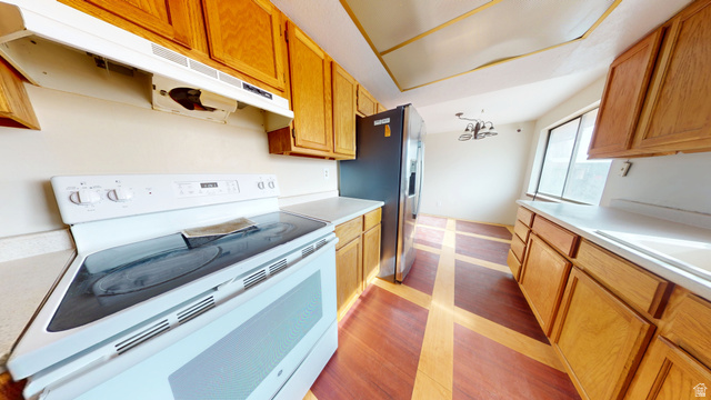 1348 Sagewood Road Price, UT 84501 - Photo 10 of 34 Kitchen with electric range, light countertops, stainless steel fridge with ice dispenser, wood finish cabinetry, and suspended lighting