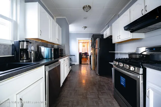 a view of a kitchen with fridge and workspace