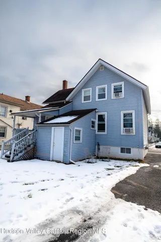 a view of a house with a yard covered in snow