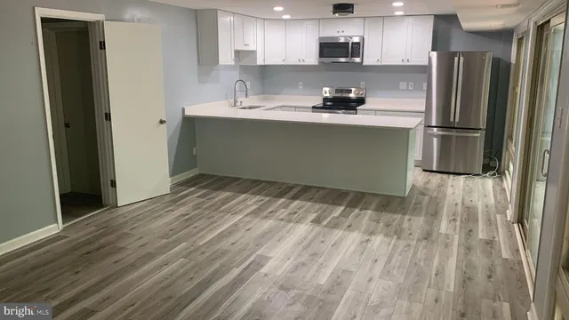 a kitchen with stainless steel appliances granite countertop a refrigerator sink and microwave