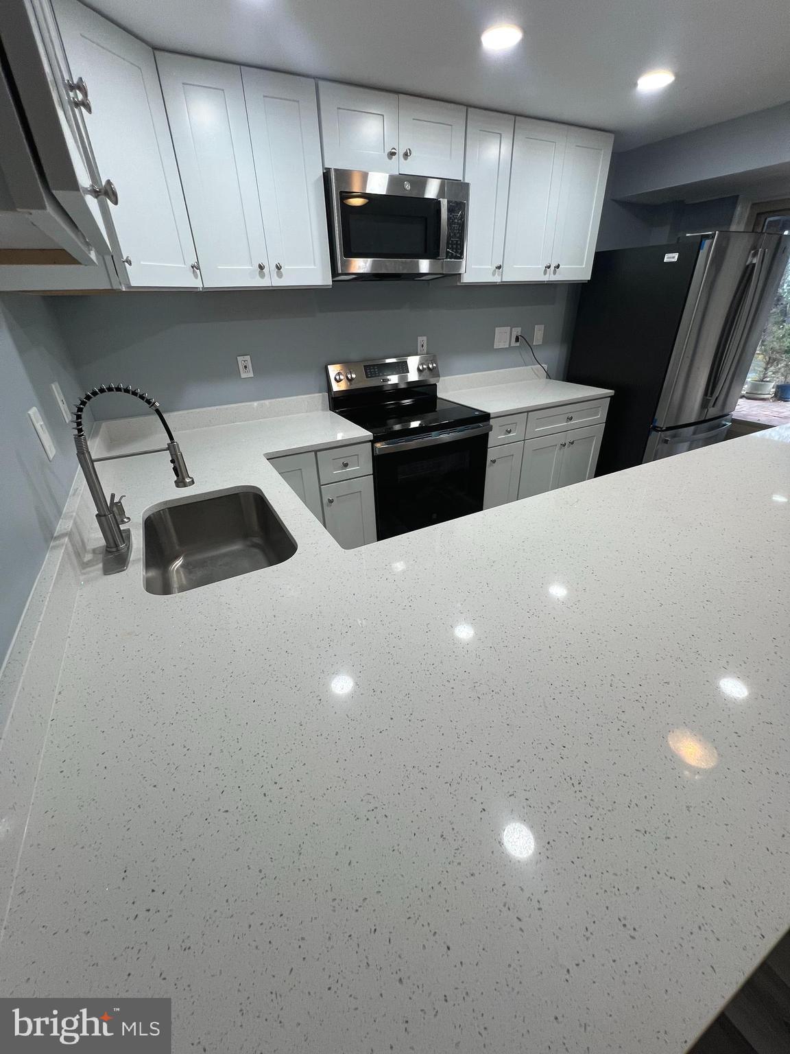 11823 Falls Road Potomac, MD 20854 - Photo 5 of 20 a kitchen with stainless steel appliances a sink a stove a refrigerator a sink and cabinets