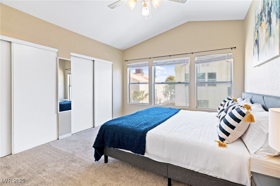 8213 Grassy Point Circle Las Vegas, NV 89145 - Photo 16 of 31 Bedroom featuring a ceiling fan, carpet, vaulted ceiling, and multiple closets