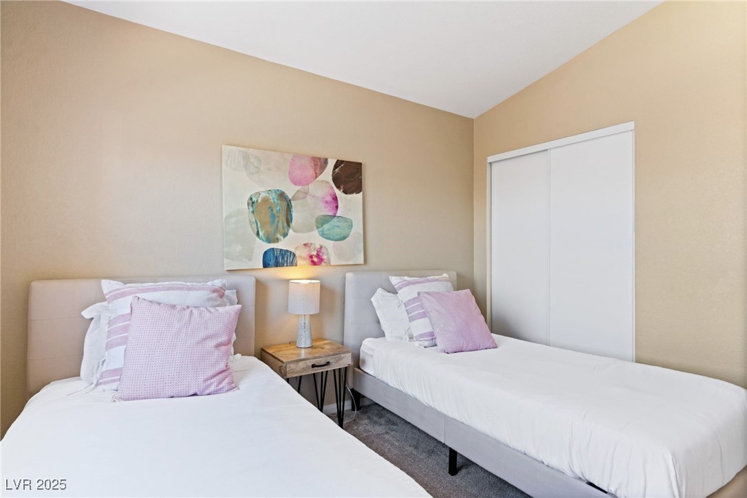8213 Grassy Point Circle Las Vegas, NV 89145 - Photo 20 of 31 Bedroom featuring carpet, a closet, and vaulted ceiling