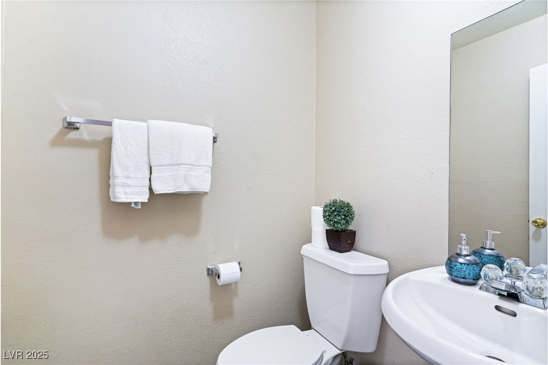 8213 Grassy Point Circle Las Vegas, NV 89145 - Photo 22 of 31 Half bath with toilet and a sink