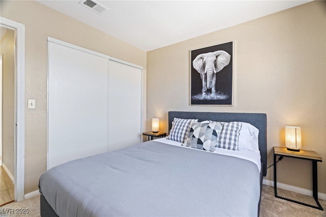 8213 Grassy Point Circle Las Vegas, NV 89145 - Photo 24 of 31 Bedroom featuring a closet, visible vents, light colored carpet, and baseboards