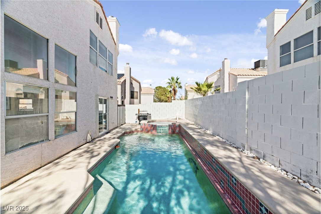 8213 Grassy Point Circle Las Vegas, NV 89145 - Photo 28 of 31 View of pool with a patio area, a fenced backyard, a pool with connected hot tub, and a residential view
