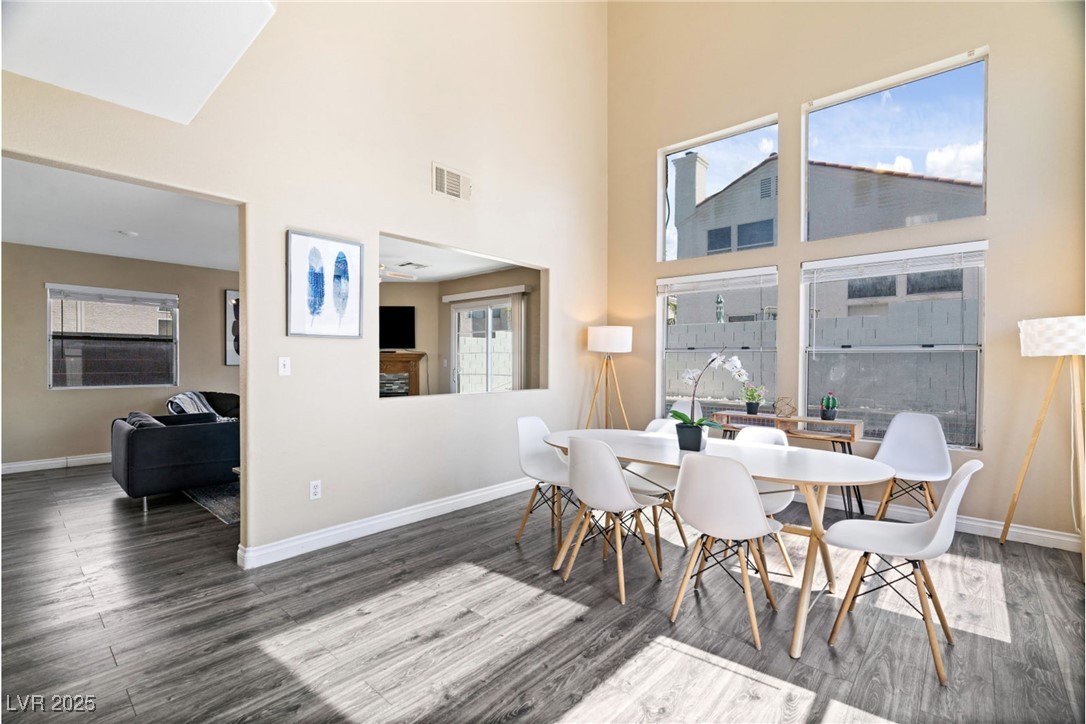 8213 Grassy Point Circle Las Vegas, NV 89145 - Photo 4 of 31 Dining space with a towering ceiling, visible vents, baseboards, and wood finished floors
