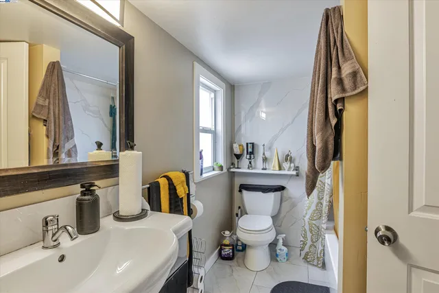 a bathroom with a granite countertop sink and a toilet
