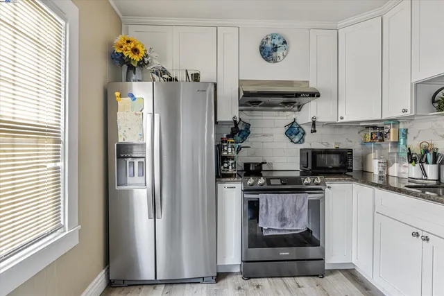 a kitchen with stainless steel appliances granite countertop a stove and a refrigerator