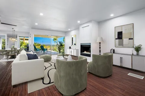 an empty room with wooden floor fireplace and windows