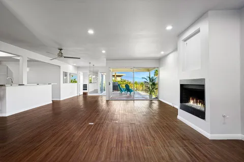 a view of empty room with wooden floor and fireplace