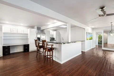 a kitchen with wooden floor and stainless steel appliances