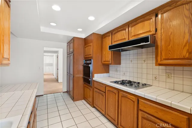 a kitchen with stainless steel appliances granite countertop a stove a sink and a refrigerator