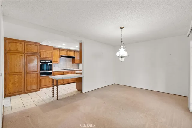an empty room with chandelier fan and windows