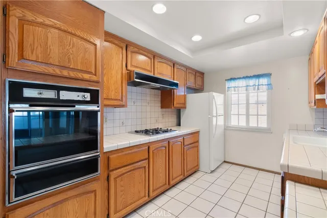 a kitchen with stainless steel appliances granite countertop a refrigerator and a stove