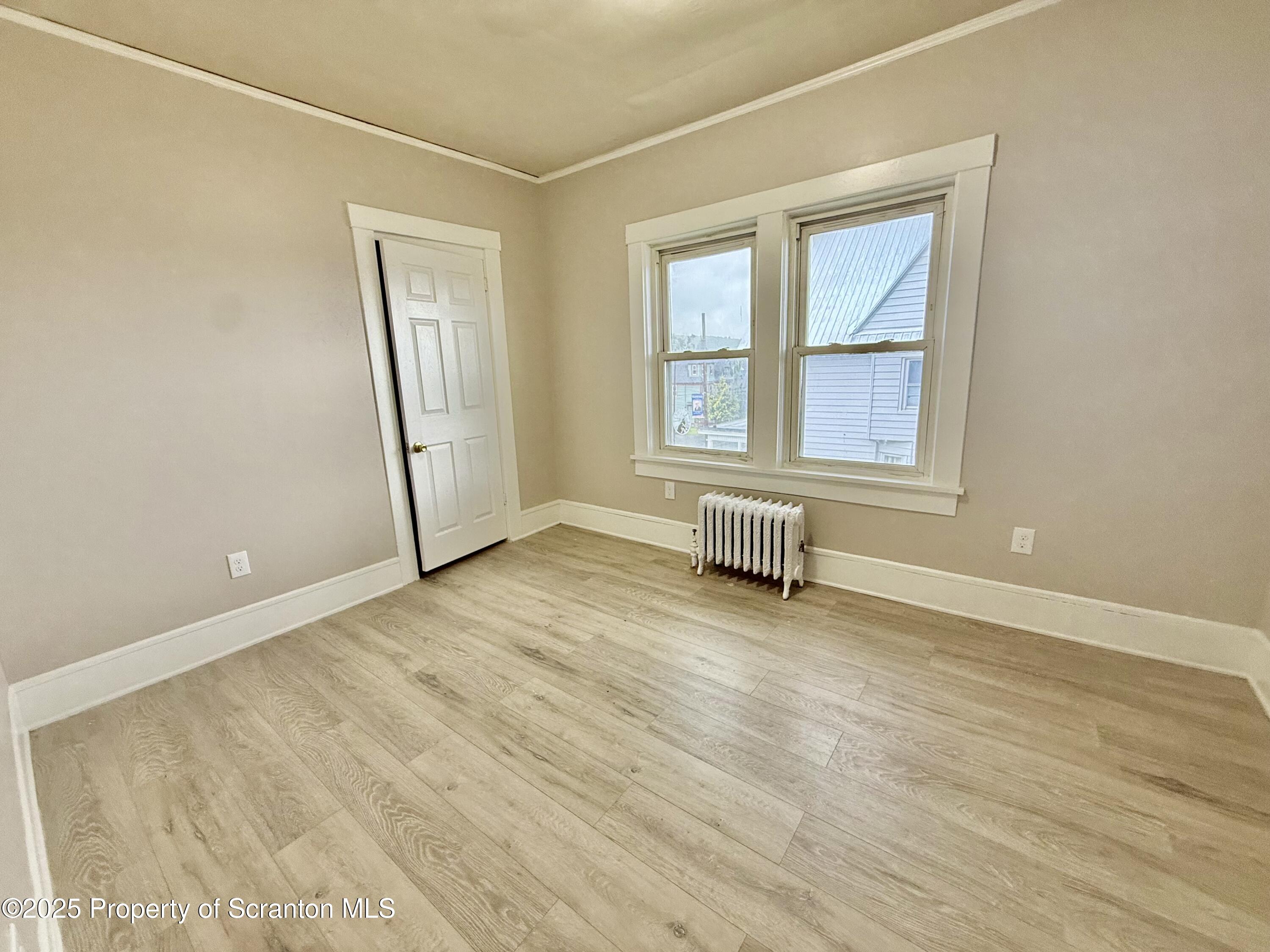 611 Harrison Avenue Scranton, PA 18510 - Photo 12 of 18 an empty room with wooden floor and windows