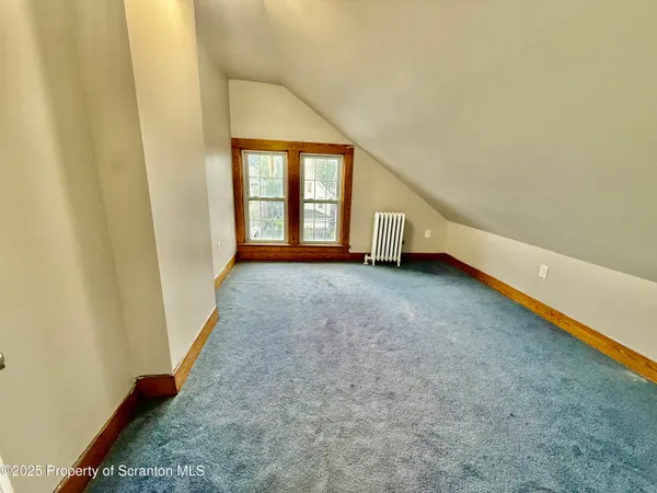 an empty room with wooden floor and white walls