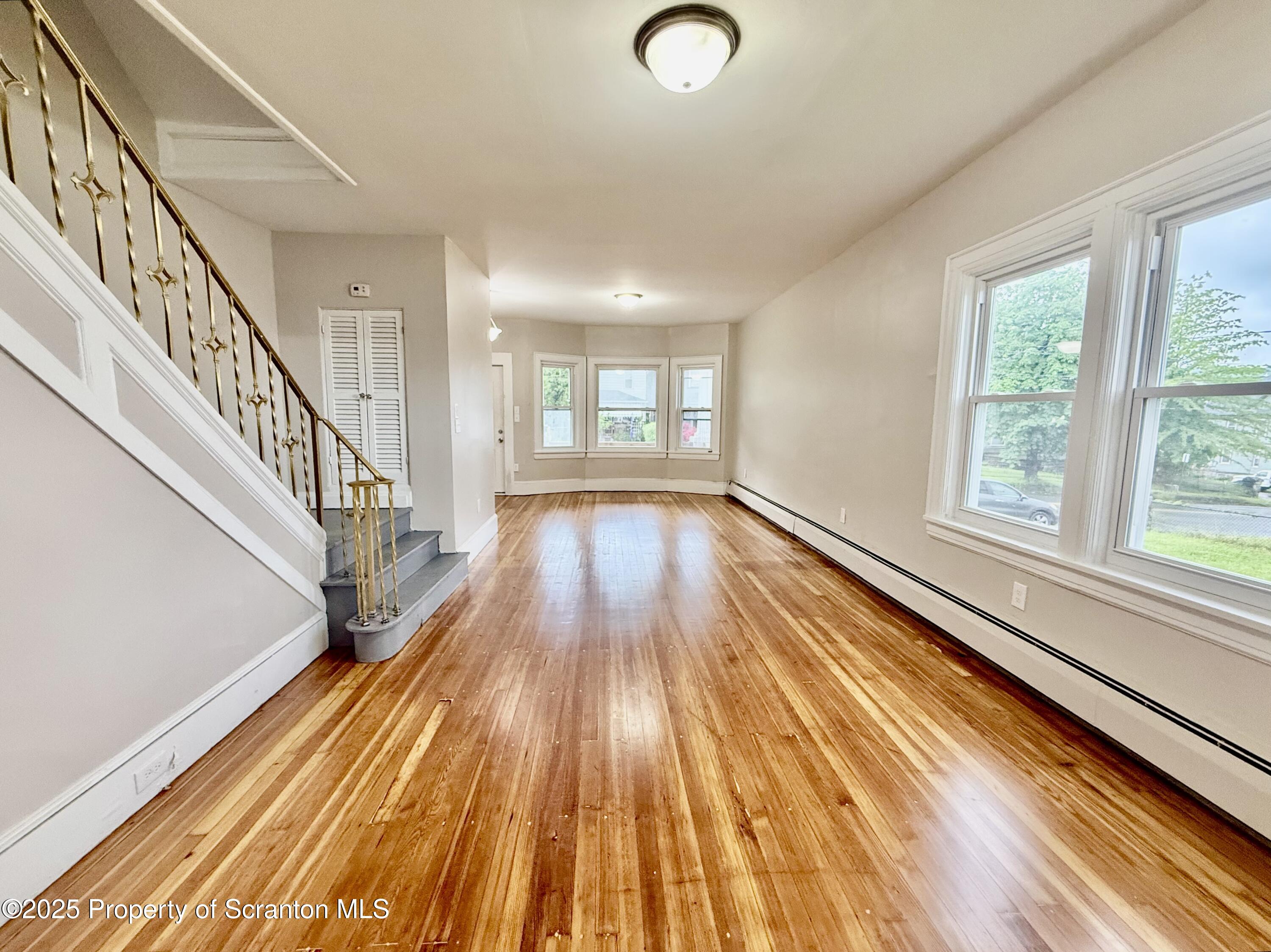 611 Harrison Avenue Scranton, PA 18510 - Photo 2 of 18 a view of an empty room with wooden floor and a window