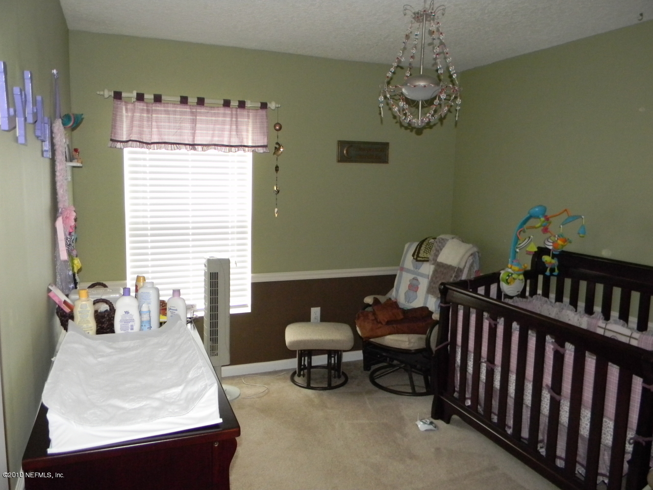 7920 Merrill Road, Unit 714 Jacksonville, FL 32277 - Photo 11 of 12 a bedroom with furniture and a chandelier