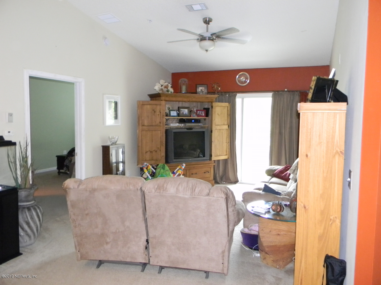 7920 Merrill Road, Unit 714 Jacksonville, FL 32277 - Photo 2 of 12 a living room with furniture a fireplace and a flat screen tv