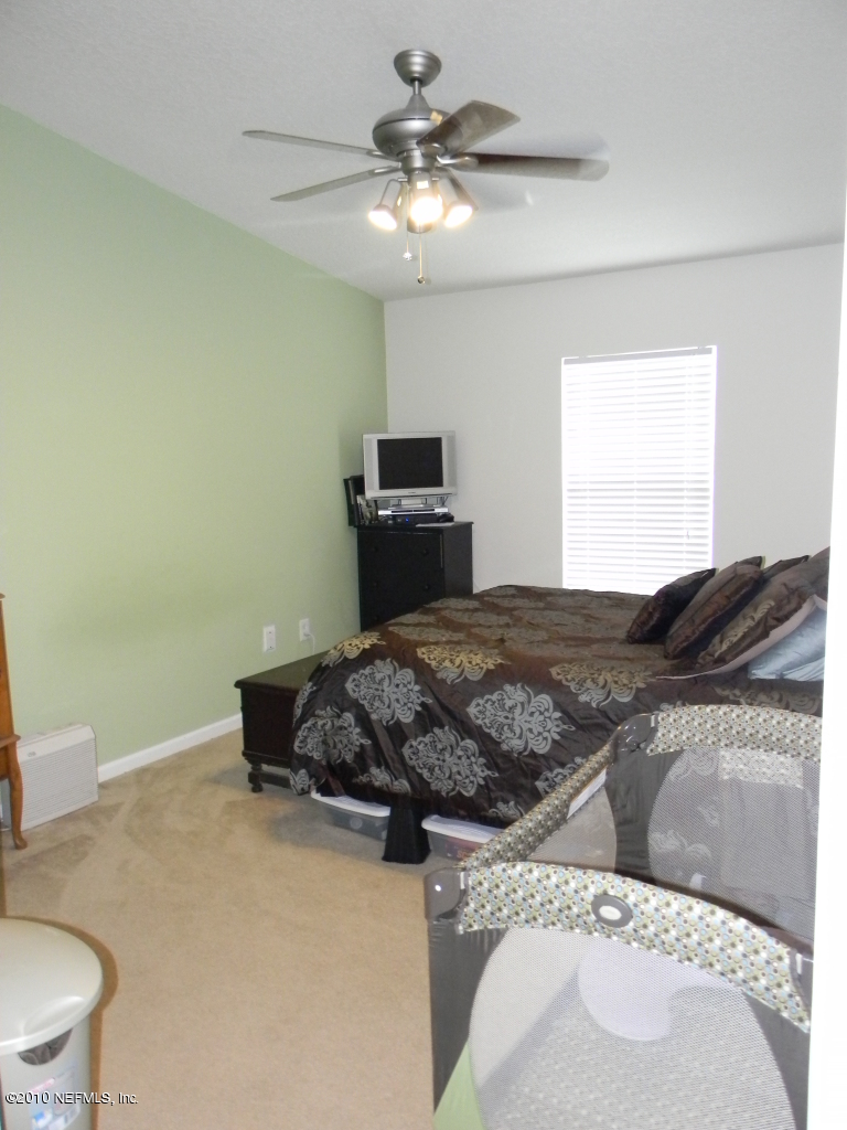 7920 Merrill Road, Unit 714 Jacksonville, FL 32277 - Photo 8 of 12 a bedroom with a bed and a chandelier