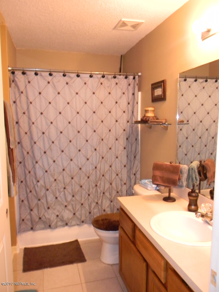 7920 Merrill Road, Unit 714 Jacksonville, FL 32277 - Photo 10 of 12 a bathroom with a sink toilet and shower