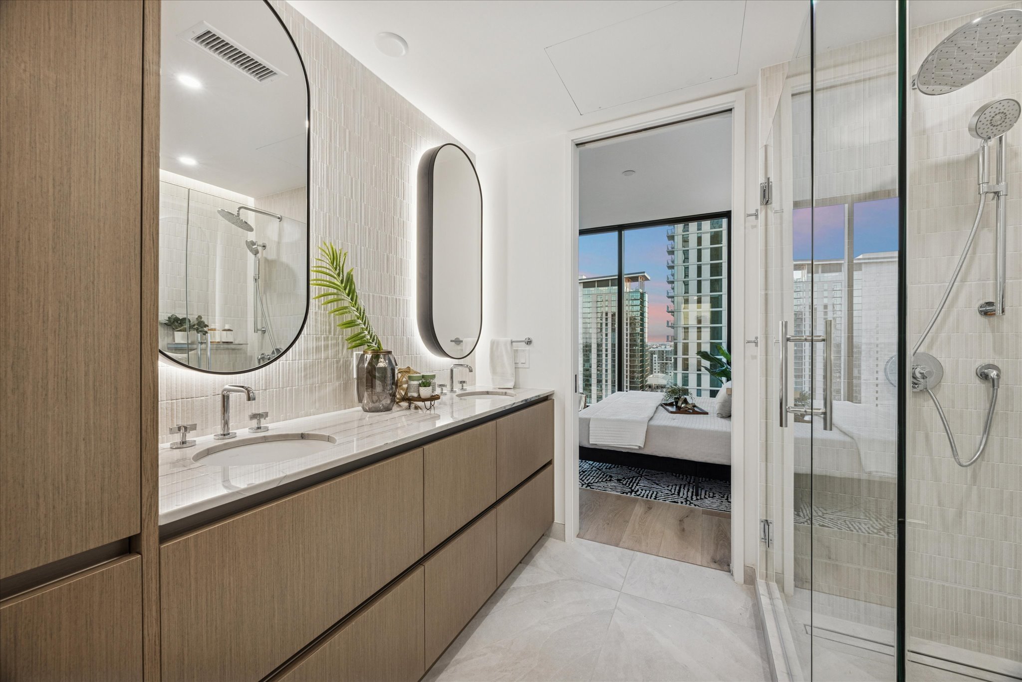 610 Davis Street, Unit 3102 Austin, TX 78701 - Photo 15 of 40 a en suite bathroom with a granite countertop sink mirror and shower