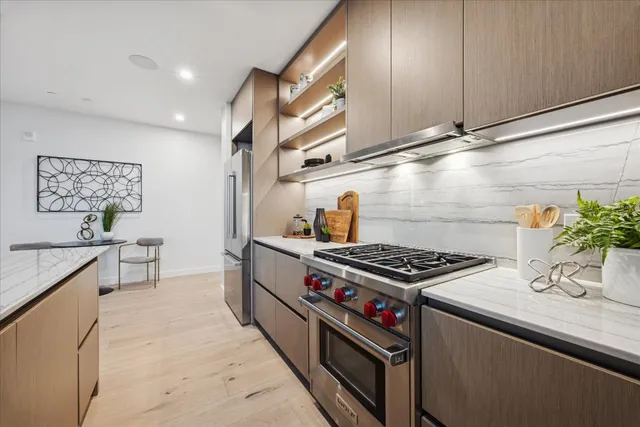 a kitchen with stainless steel appliances granite countertop a refrigerator and a stove