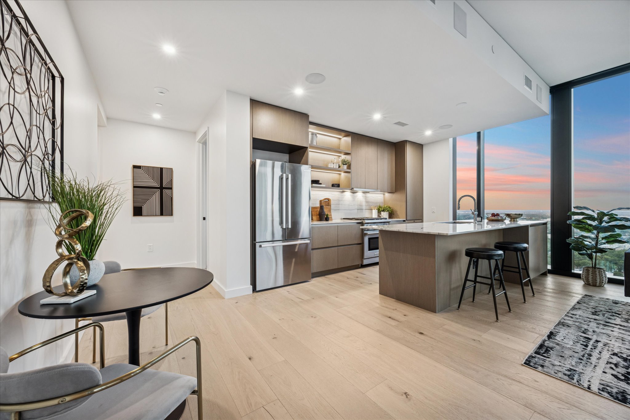 610 Davis Street, Unit 3102 Austin, TX 78701 - Photo 7 of 40 a kitchen with stainless steel appliances kitchen island granite countertop a dining table chairs refrigerator and sink