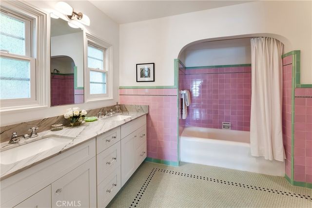 a spacious bedroom with a bed a table and chair with the large windows