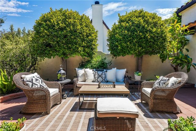 a view of a patio with couches table and chairs and potted plants