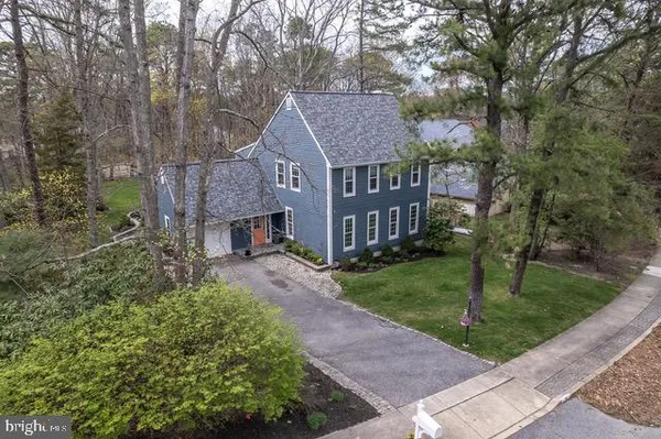 a front view of a house with a garden and trees