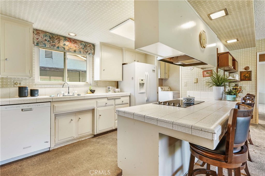 1423 La Canada Drive Brea, CA 92821 - Photo 21 of 43 a kitchen with a sink a stove a refrigerator and white cabinets