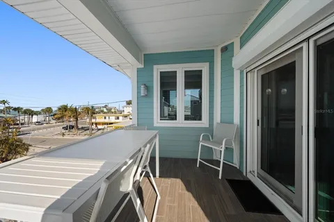 a living room with furniture a flat screen tv and kitchen view