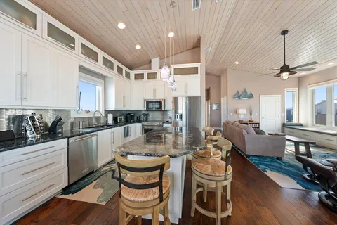 a dining room with furniture water view and a floor to ceiling window