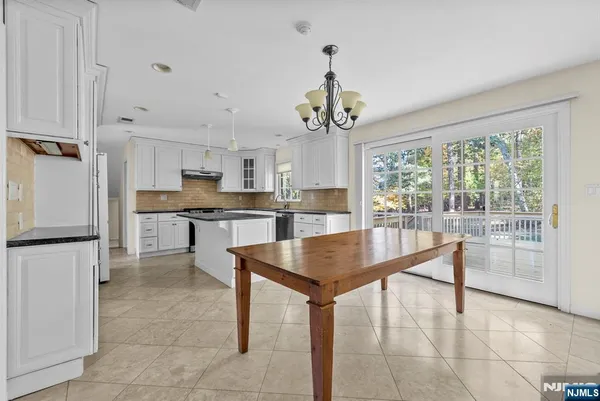 a living room with couches and kitchen view with wooden floor