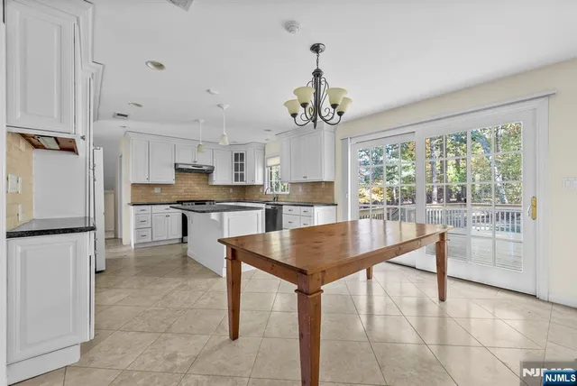 a living room with couches and kitchen view with wooden floor
