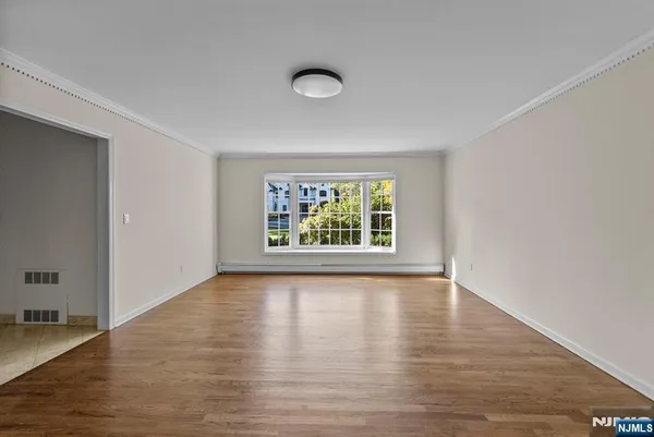 a view of a hallway with wooden floor and a bathroom