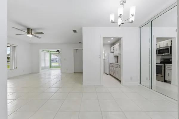 a view of a hallway with wooden floor and a kitchen