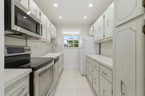 a kitchen with stainless steel appliances granite countertop a refrigerator and a stove