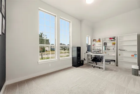 a view of a workspace with furniture and a window